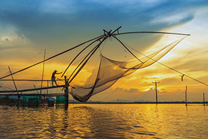 רשת דייג ענקית לרקע שקיעה בדלתת המקונג בווייטנאם